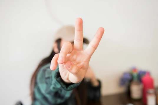 Close-up of a hand showing the peace sign